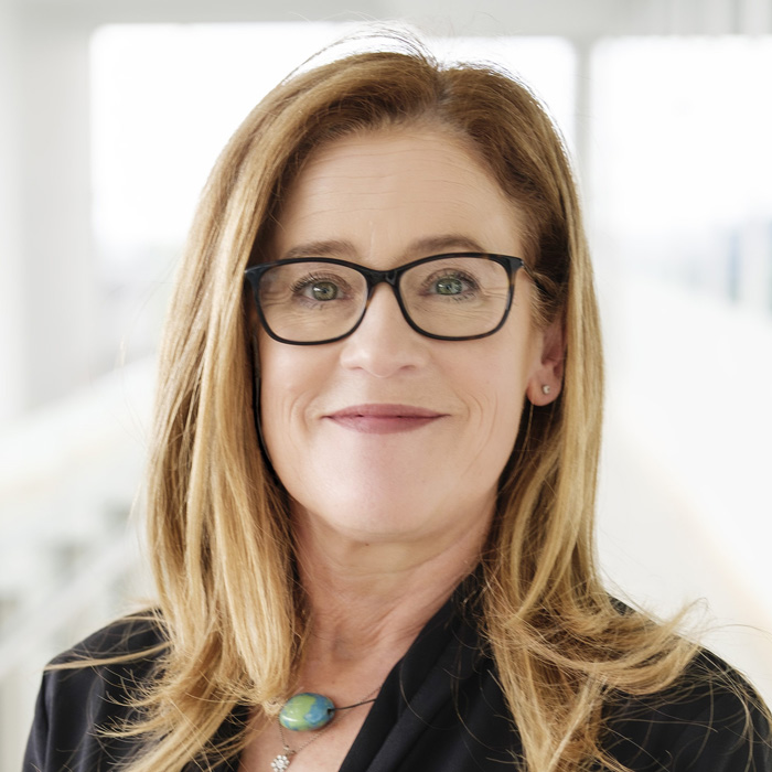 Woman with blonde hair and glasses.